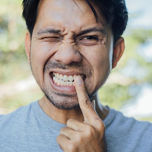 man with tooth pain in need of a root canal in Mississauga